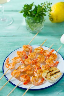 Ahşap yüzeyde ızgara karides şişleri.