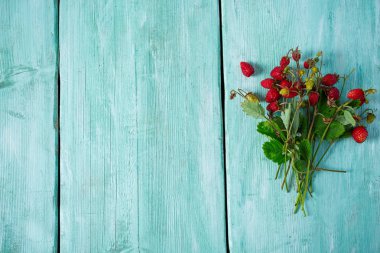 Turkuaz yüzeyinde yabani çilekler