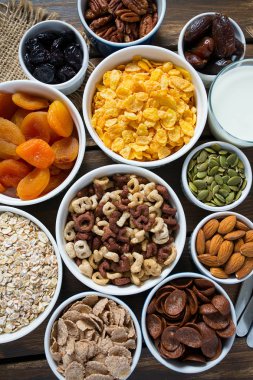 Tahta yüzeyde çeşitli tahıllar, fındıklar ve kurutulmuş meyveler.