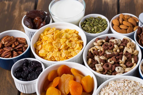 Tahta yüzeyde çeşitli tahıllar, fındıklar ve kurutulmuş meyveler.