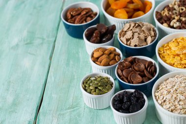 Tahta yüzeyde çeşitli tahıllar, fındıklar ve kurutulmuş meyveler.