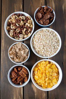 Tahta yüzeyde çeşitli tahıllar, fındıklar ve kurutulmuş meyveler.