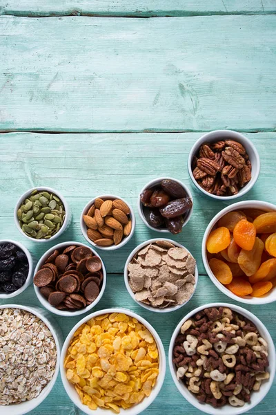 Tahta yüzeyde çeşitli tahıllar, fındıklar ve kurutulmuş meyveler.