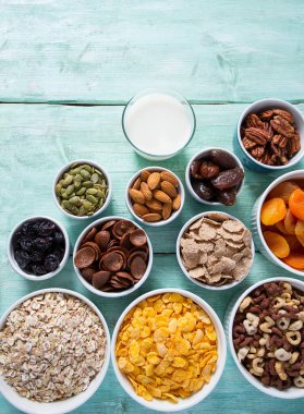 Tahta yüzeyde çeşitli tahıllar, fındıklar ve kurutulmuş meyveler.