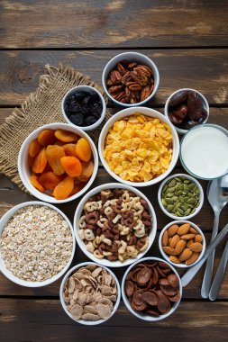 Tahta yüzeyde çeşitli tahıllar, fındıklar ve kurutulmuş meyveler.
