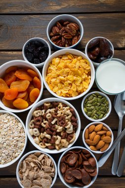 Tahta yüzeyde çeşitli tahıllar, fındıklar ve kurutulmuş meyveler.