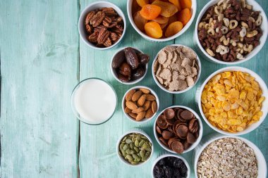 Tahta yüzeyde çeşitli tahıllar, fındıklar ve kurutulmuş meyveler.