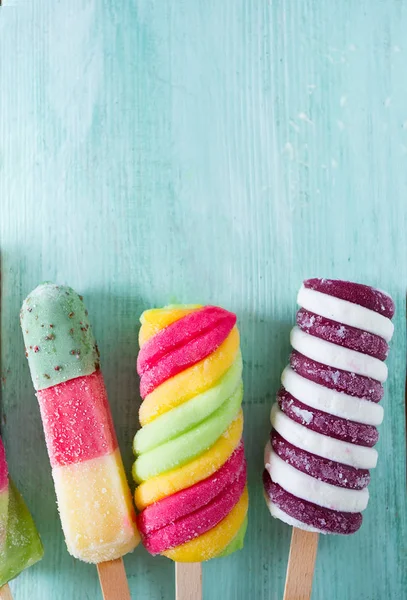 青緑色の木製の背景にカラフルなアイス キャンデー アイスクリーム — ストック写真