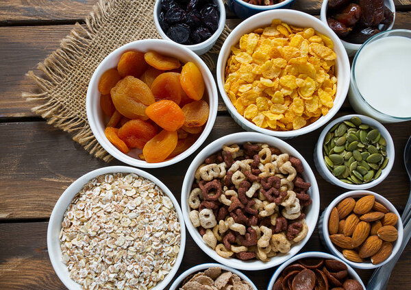 различные крупы, орехи и сухофрукты на деревянной поверхности
