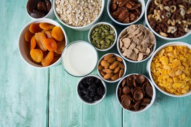 Tahta yüzeyde çeşitli tahıllar, fındıklar ve kurutulmuş meyveler.