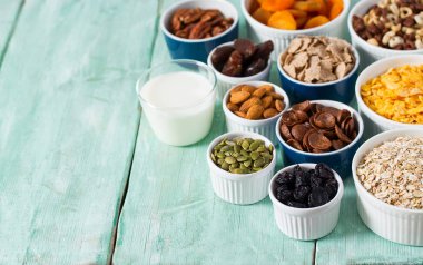 Tahta yüzeyde çeşitli tahıllar, fındıklar ve kurutulmuş meyveler.