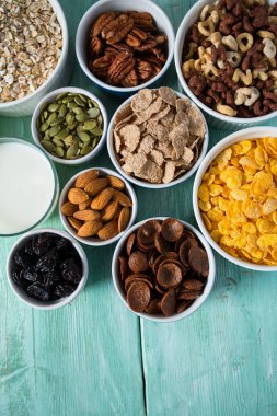 Tahta yüzeyde çeşitli tahıllar, fındıklar ve kurutulmuş meyveler.