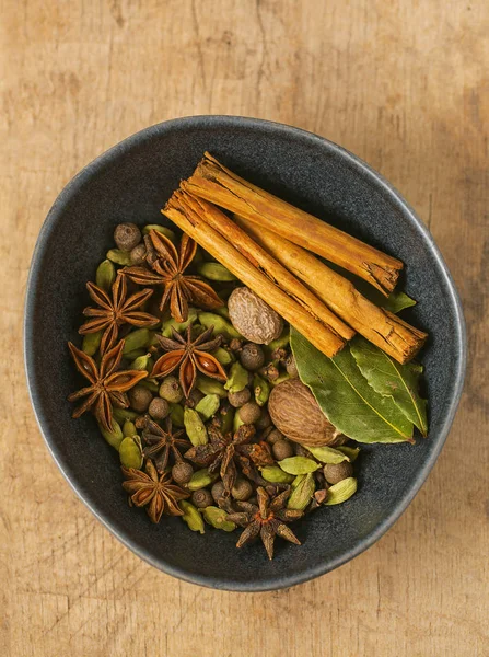 Специи для чая масала в темной миске — стоковое фото