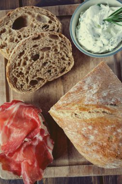 tahta yüzeyde coppa di parma et, krem peynir ve ciabatta ekmek