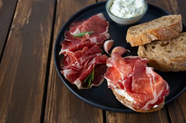 tahta yüzeyde coppa di parma et, krem peynir ve ciabatta ekmek