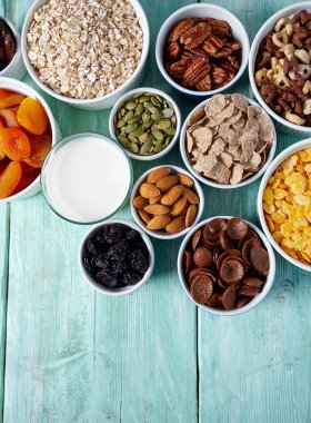 Tahta yüzeyde çeşitli tahıllar, fındıklar ve kurutulmuş meyveler.