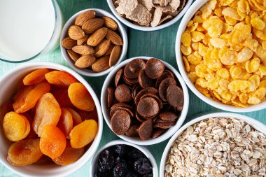 Tahta yüzeyde çeşitli tahıllar, fındıklar ve kurutulmuş meyveler.