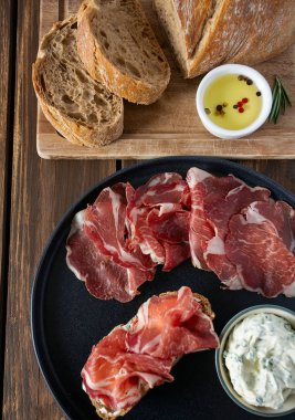 tahta yüzeyde coppa di parma et, krem peynir ve ciabatta ekmek