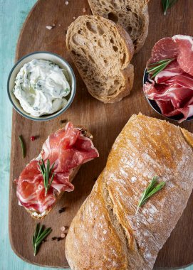 tahta yüzeyde coppa di parma et, krem peynir ve ciabatta ekmek