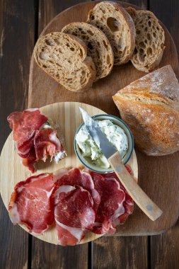 tahta yüzeyde coppa di parma et, krem peynir ve ciabatta ekmek