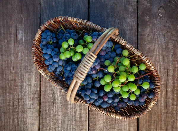 Корзина с виноградом на деревянной поверхности — стоковое фото