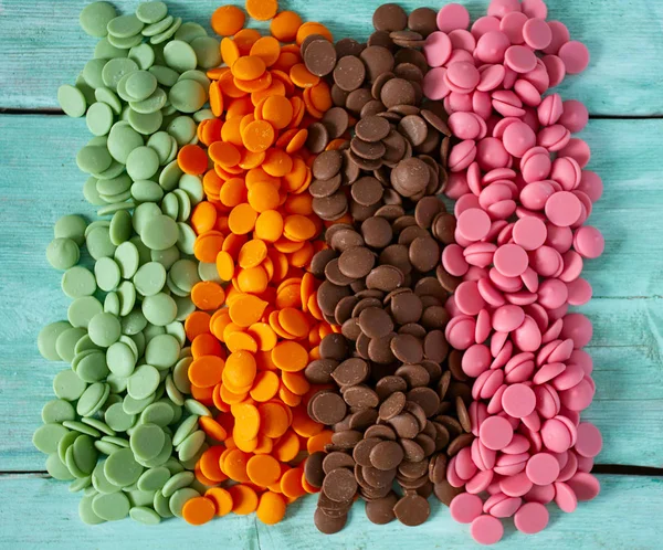 Jahodové, oranžové a vápenné čokoládové hranolky na tyrkysové ploše — Stock fotografie