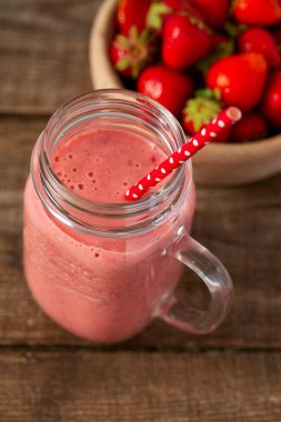 Tahta yüzeyde çilekli milkshake.