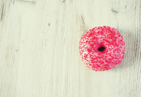 Doughnut on wooden surface — Stock Photo, Image
