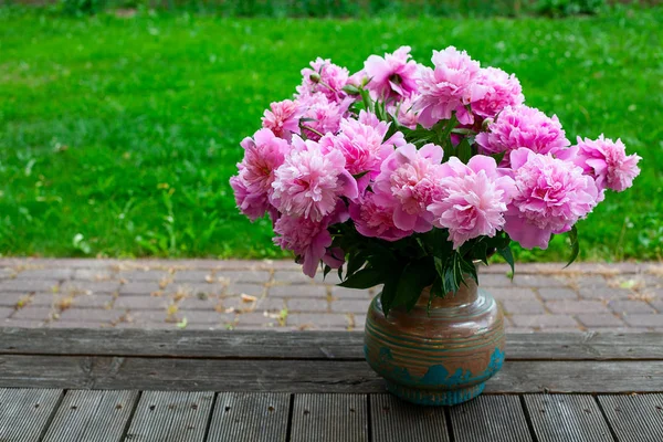 bouquet of peonies in vase in garden