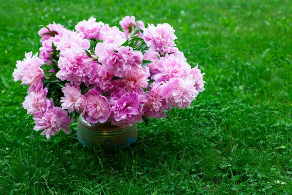 bouquet of peonies in vase in garden