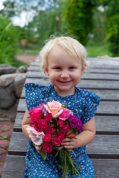 Милая блондинка держит букет цветов — стоковое фото