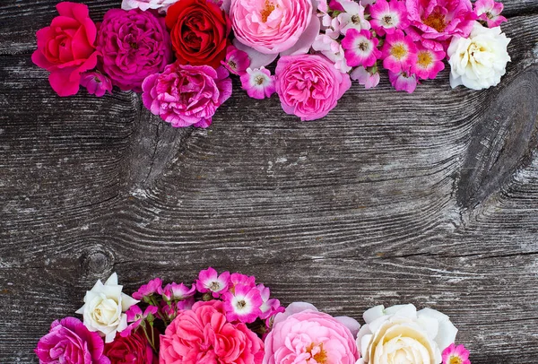 Pink,red, violet and white roses on wooden surface — Stock Photo, Image