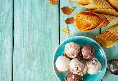 turkuaz ahşap yüzeyüzerinde dondurma ve waffle konileri