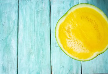 turkuaz yüzeyinde sarı karpuzun yarısı