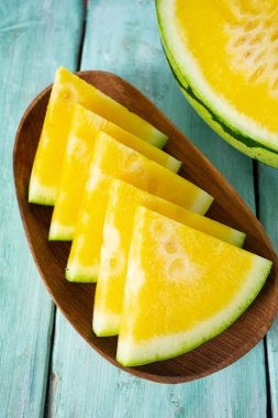 Ahşap masa üzerinde sarı karpuz dilimli 