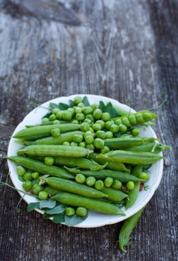 koyu ahşap yüzeyde taze bezelye