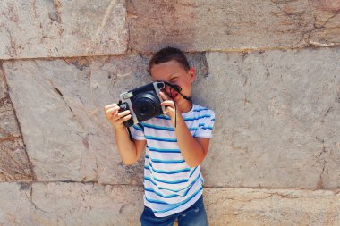 Vintage kamera kullanarak fotoğraf yapan çocuk