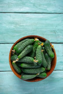 Ahşap yüzeydeki bir kasede salatalıklar.