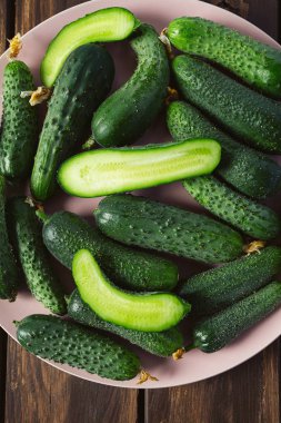 Ahşap yüzeydeki bir kasede salatalıklar.