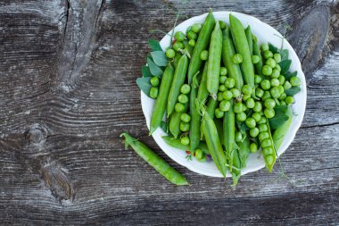 koyu ahşap yüzeyde taze bezelye