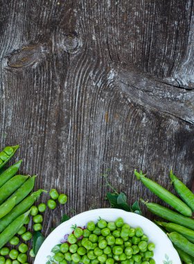 koyu ahşap yüzeyde taze bezelye