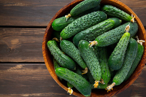 огурцы в чаше на деревянной поверхности
