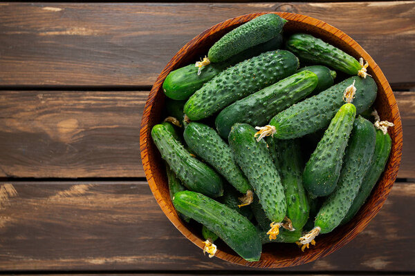 огурцы в чаше на деревянной поверхности
