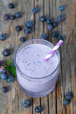 ahşap yüzeyüzerinde bir bardak yaban mersini smoothie