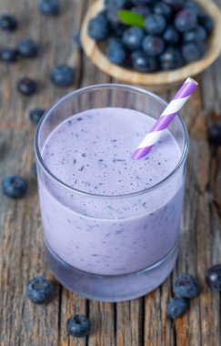 ahşap yüzeyüzerinde bir bardak yaban mersini smoothie