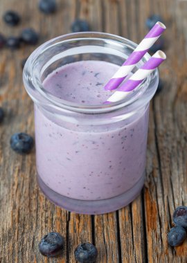 ahşap yüzeyüzerinde bir bardak yaban mersini smoothie