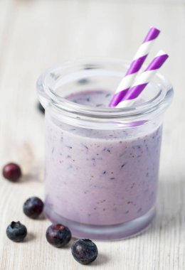 ahşap yüzeyüzerinde bir bardak yaban mersini smoothie