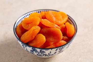 ahşap yüzeyüzerinde bir kapta kuru kayısı