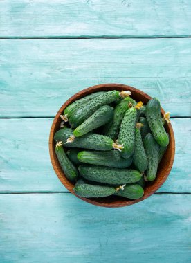 Ahşap yüzeydeki bir kasede salatalıklar.