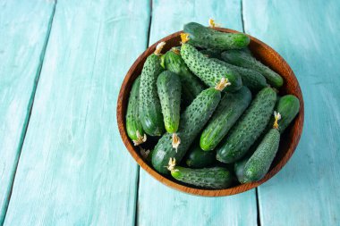 Ahşap yüzeydeki bir kasede salatalıklar.